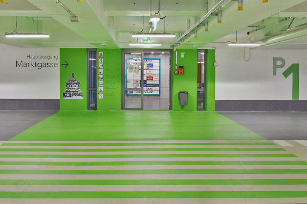 Utgång från p-hus markerad för gångtrafikanter med hjälp av ljusgrön färg.