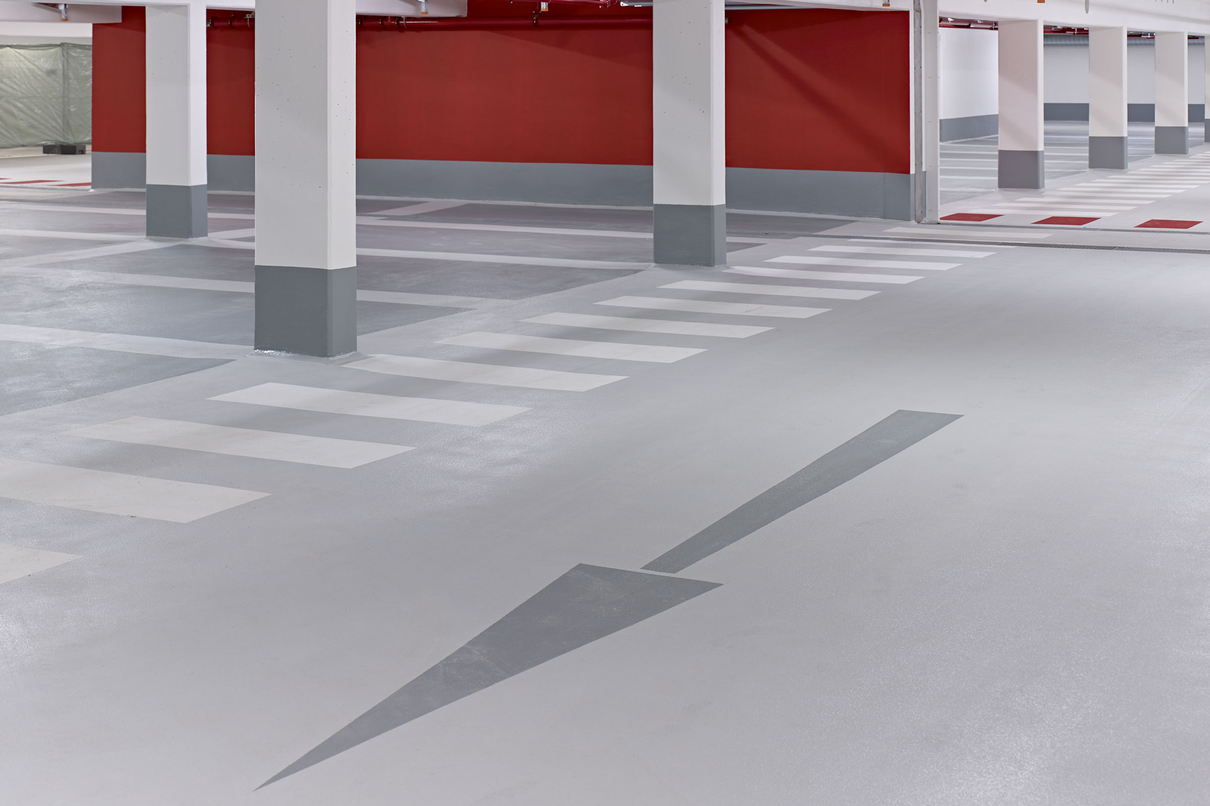 Grön körbana i parkeringshus. Grå parkeringsfickor.