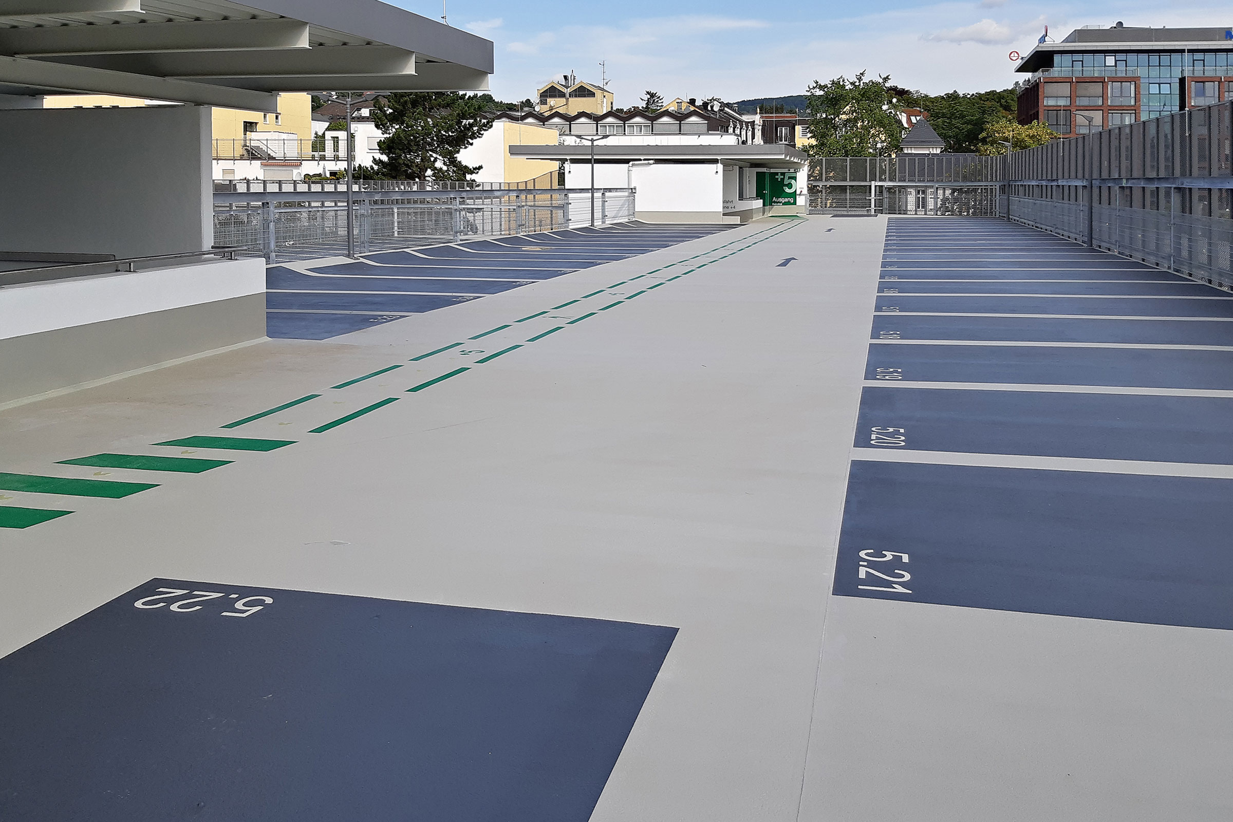 P-husyta utomhus med grå körbana och mörkblå parkeringsfickor.