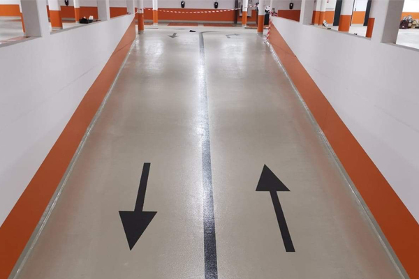 Beige ramp med orangea linjer som markerar ut körbanan och svarta pilar i körbanan.