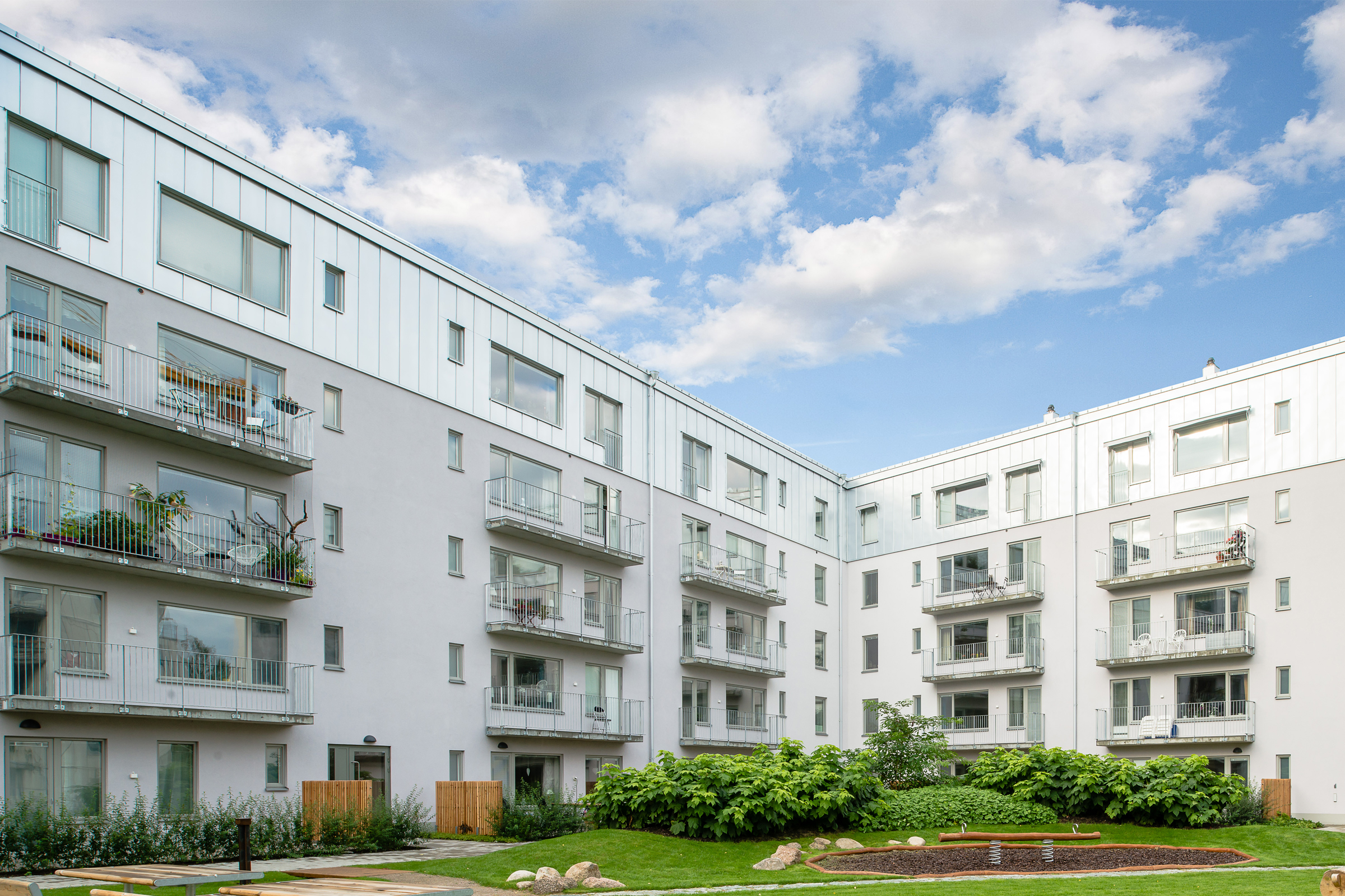 Nybyggt flerbostadshus med grå puts och isolerat fasadsystem från Sto