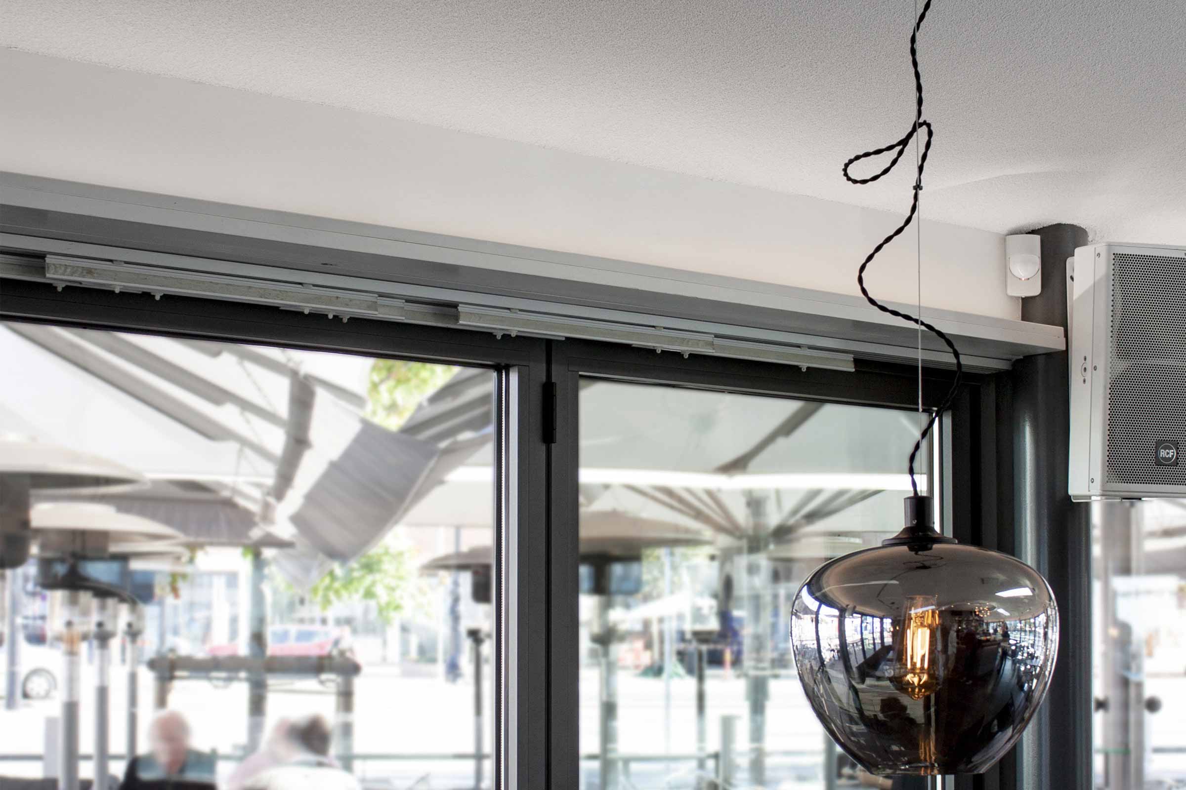 Restaurang med direktmonterat akustiktak. En lampa hänger ner från taket.