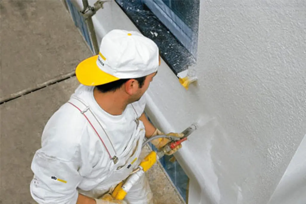 Man använder en maskin på en fasad